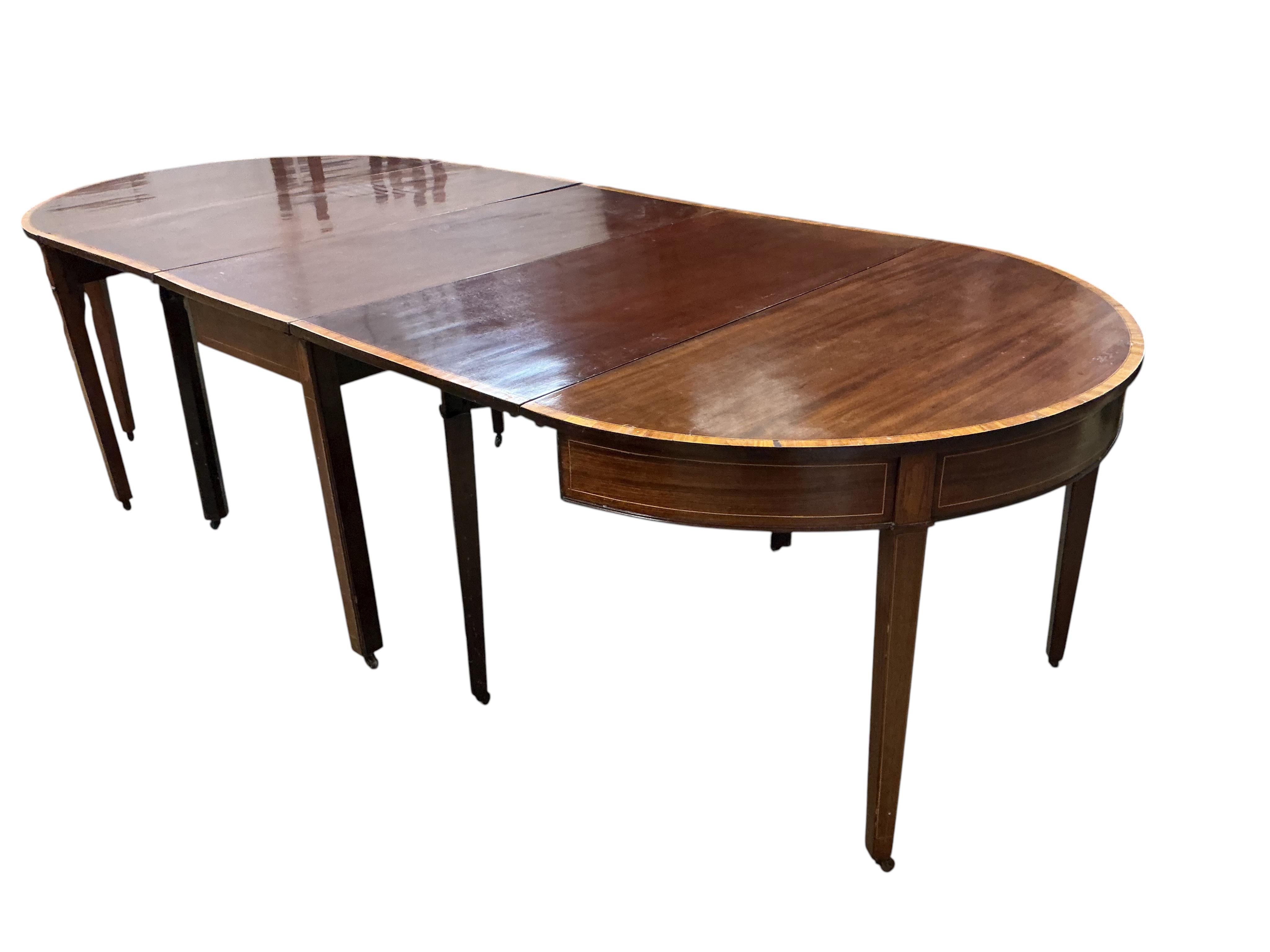 A George III satinwood banded mahogany D end extending dining table, with two spare leaves, 284cm extended, depth 120cm, height 74cm, together with a set of eight Victorian mahogany balloon back dining chairs